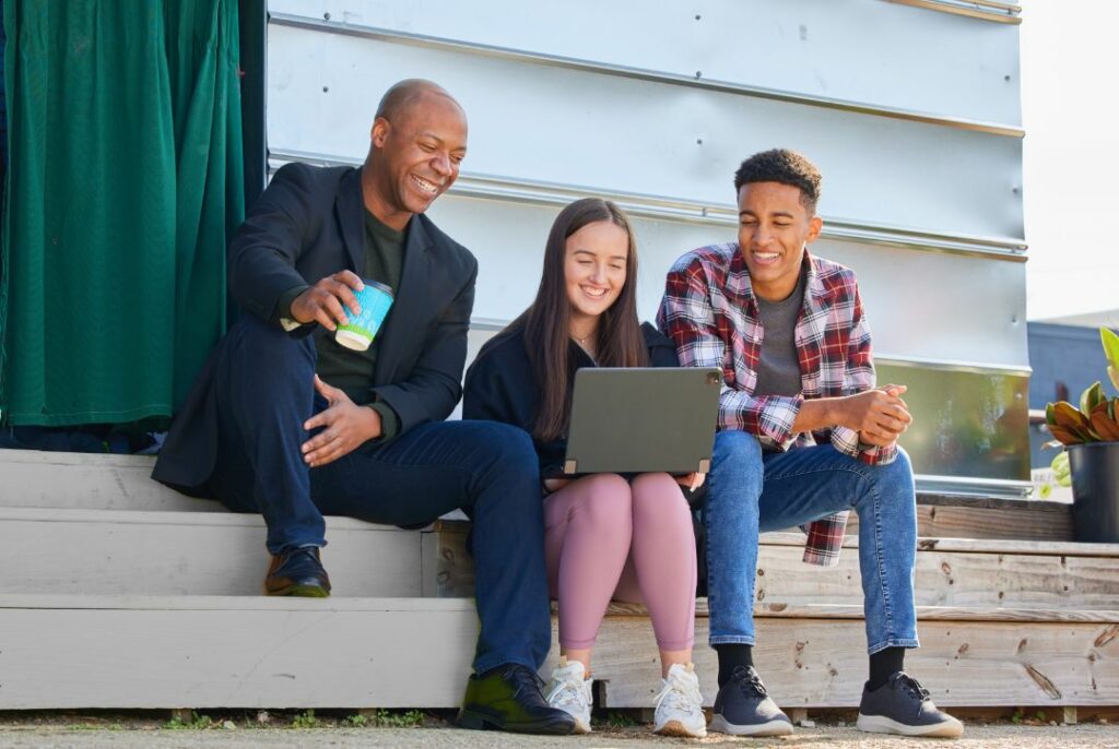 Teacher and students using laptop